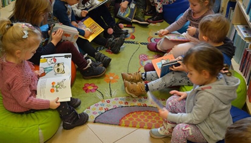dzieci z przedszkola oglądające książki w bibiliotece